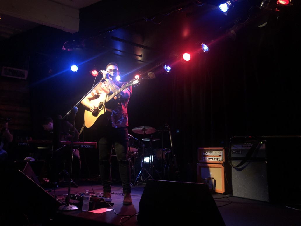 jesse denaro on stage playing an acoustic guitar