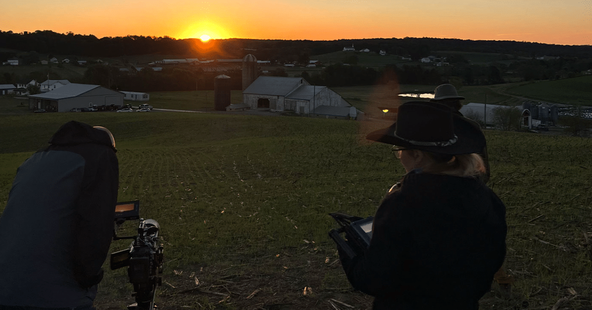 film crew outside with the sun setting behind them